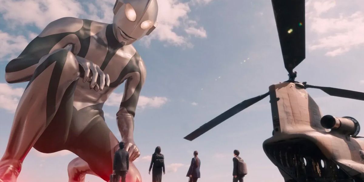 Ultraman looks down at a group of humans