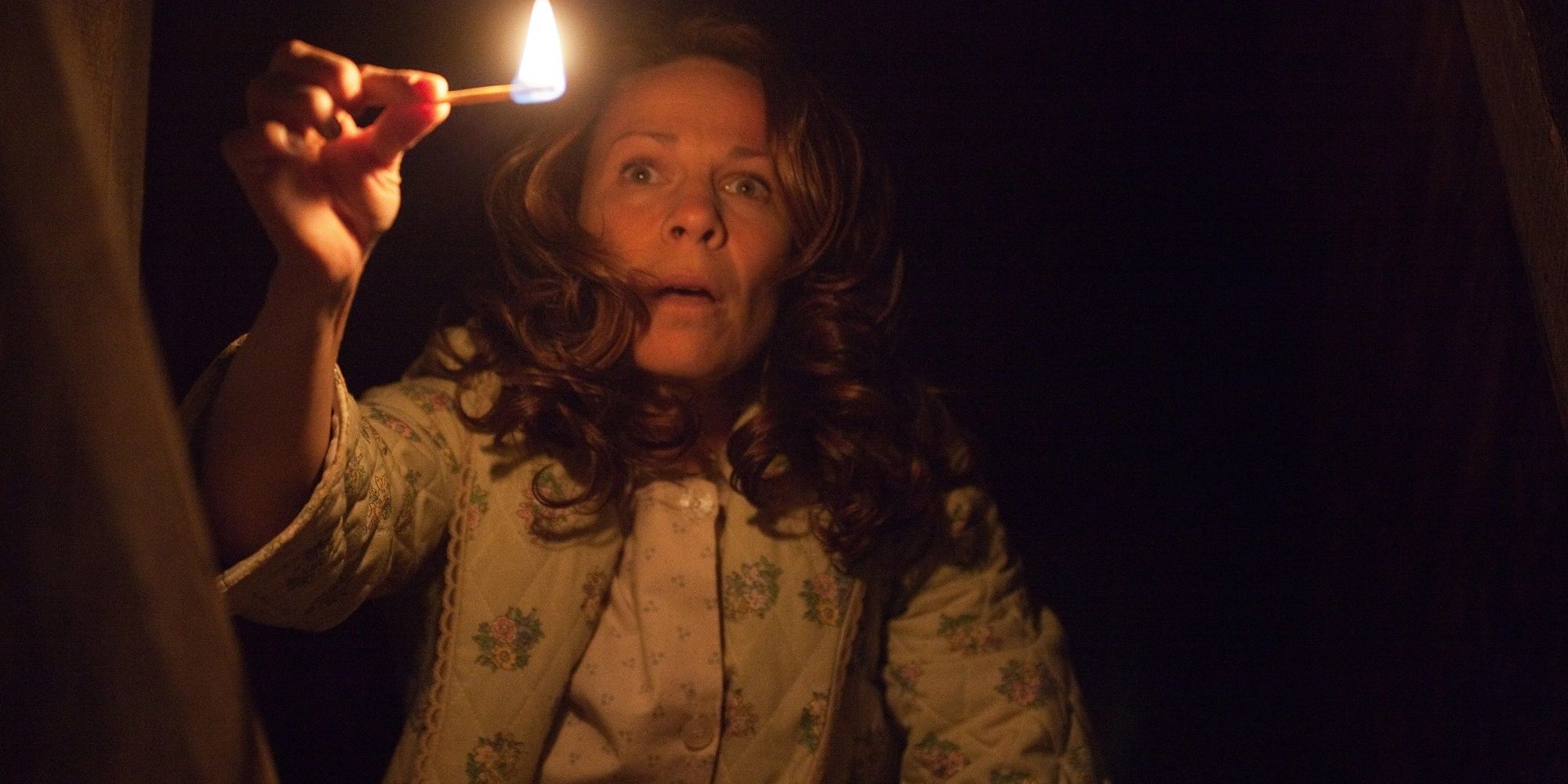 Carolyn Perron holding a match and looking into the basement in 'The Conjuring.'
