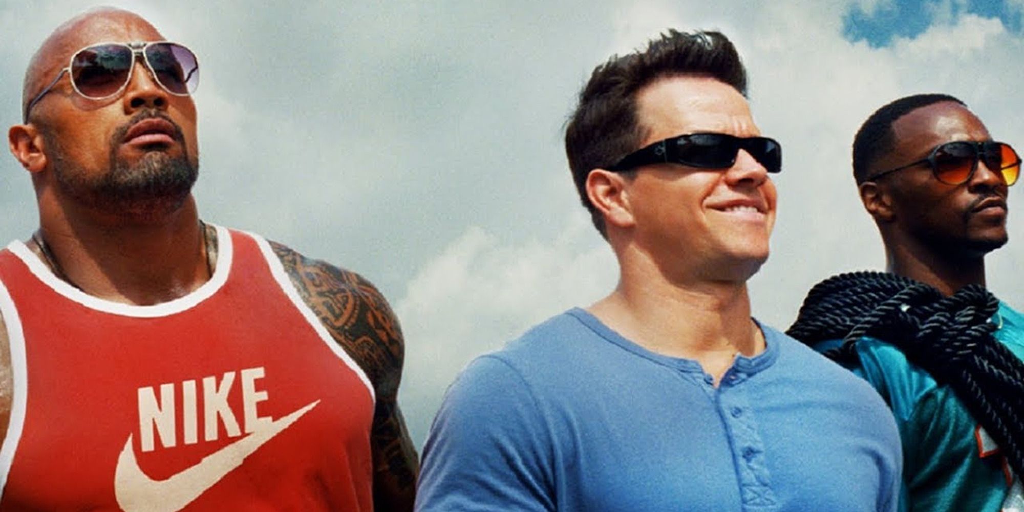 Dwayne Johnson, Mark Wahlberg, and Anthony Mackie as Paul, Daniel, and Adrian looking to the distance in Pain & Gain