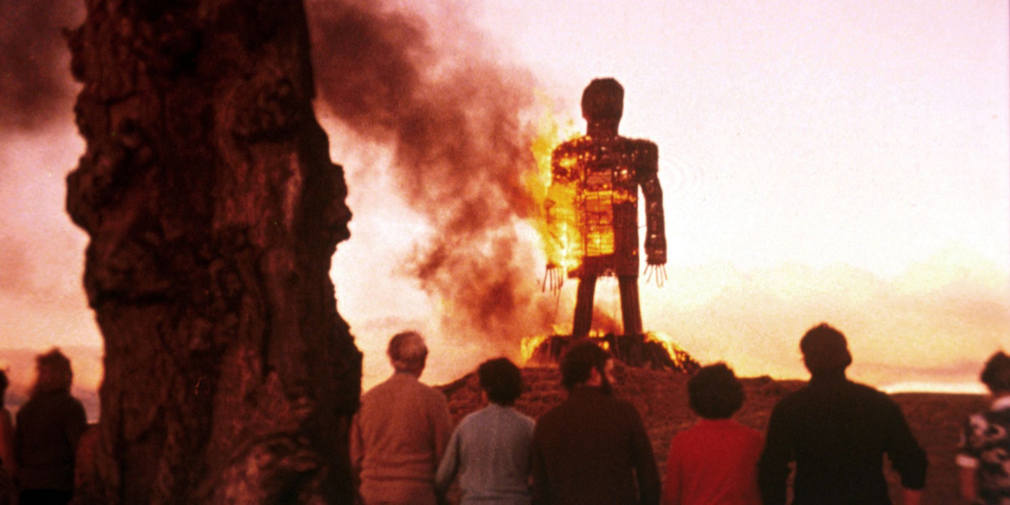 A group of people watch a burning effigy in The Wicker Man