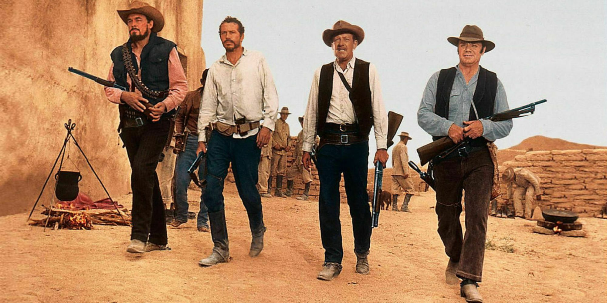 Four cowboys holding guns walking in the same direction in The Wild Bunch.