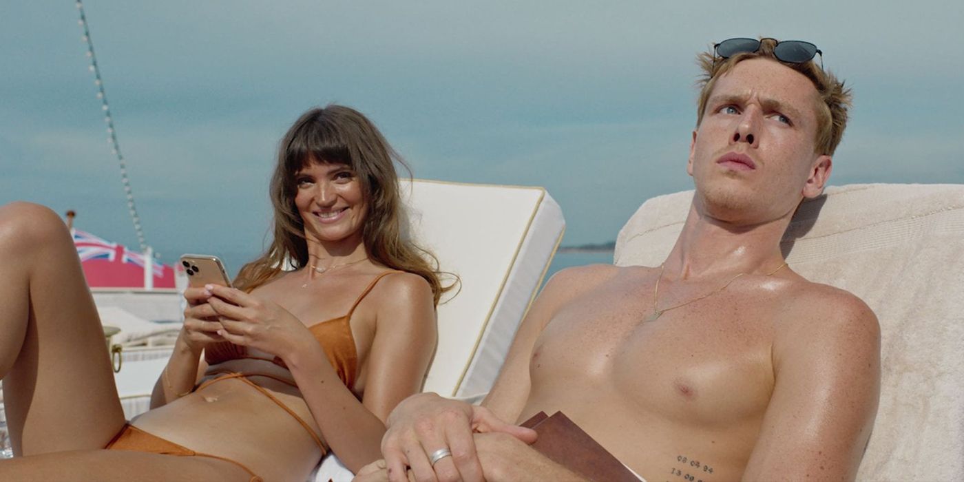 Un jeune homme et une femme prennent un bain de soleil et regardent dans la même direction dans Triangle Of Sadness.