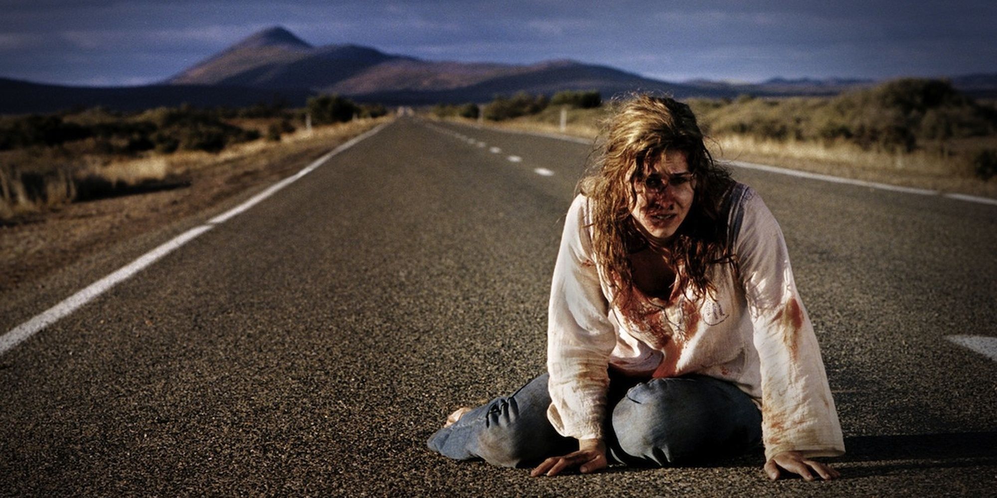 A wounded woman crawling down a road in Wolf Creek