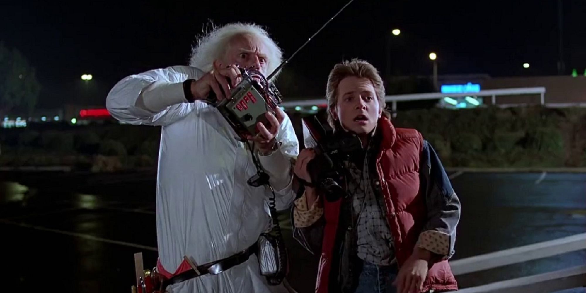 Michael J Fox, dans le rôle de Marty, et Christopher Lloyd, dans le rôle de Doc, testent la machine à voyager dans le temps télécommandée par le Docteur dans Retour vers le futur.