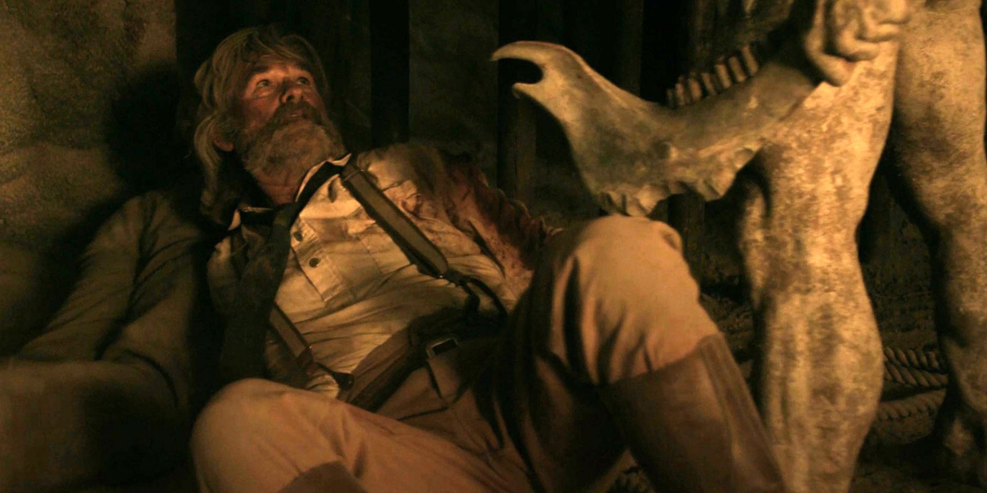 Sheriff Franklin Hunt (Kurt Russell) cowering on the ground before a man holding a bone tomahawk