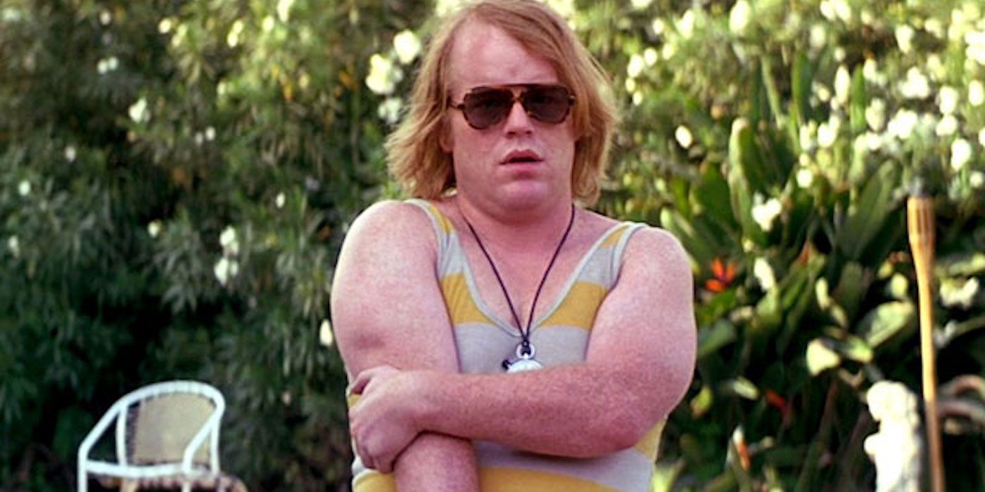 Philip Seymour Hoffman as Scotty J holding his arm tightly in Boogie Nights