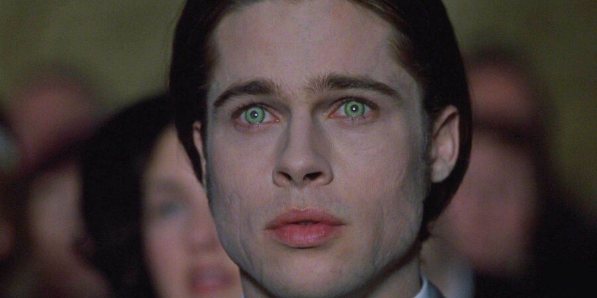 close up on a man with weirdly white skin and green eyes