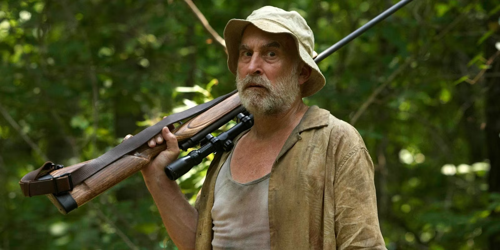 Dale stands in the forest holding his rifle over his shoulder in 'The Walking Dead'
