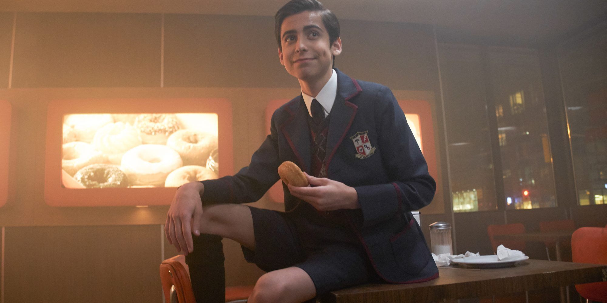 A boy with donut sitting on the table