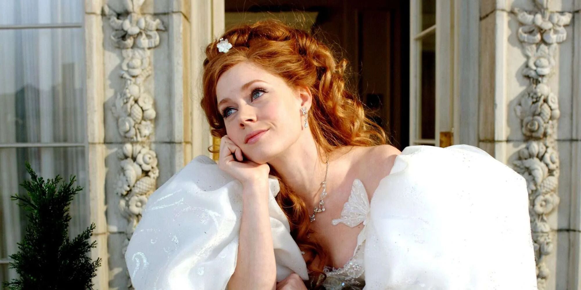 Giselle sur un balcon avec une expression rêveuse sur son visage dans Enchanted.