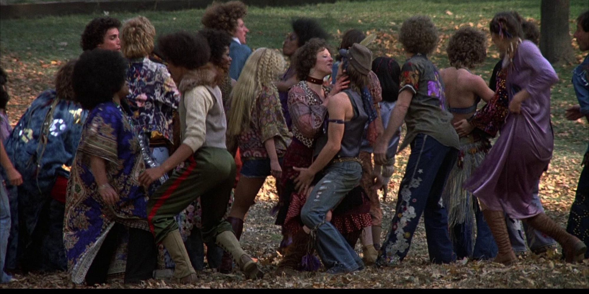 A group of people dancing on an open field in the film Hair.
