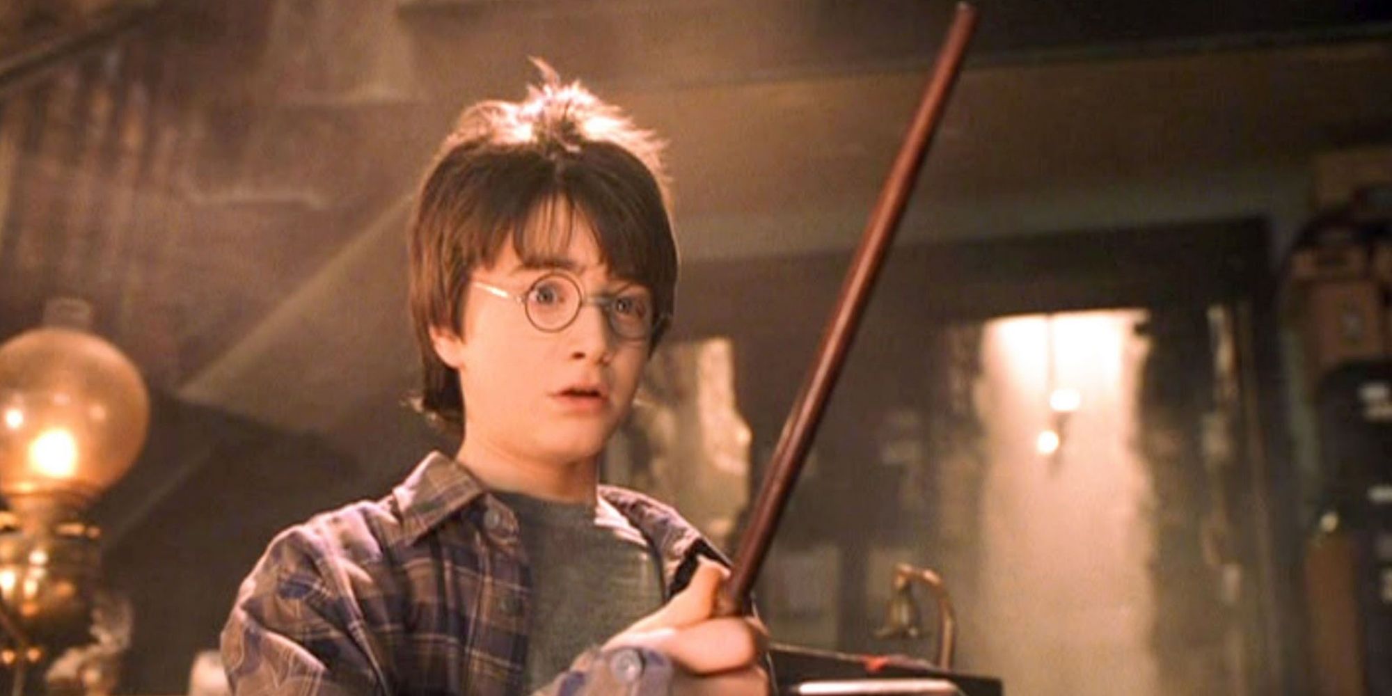 Dnaiel Radcliffe as Harry Potter looking in awe while holding his first wand in 'Harry Potter and The Sorcerer's Stone'