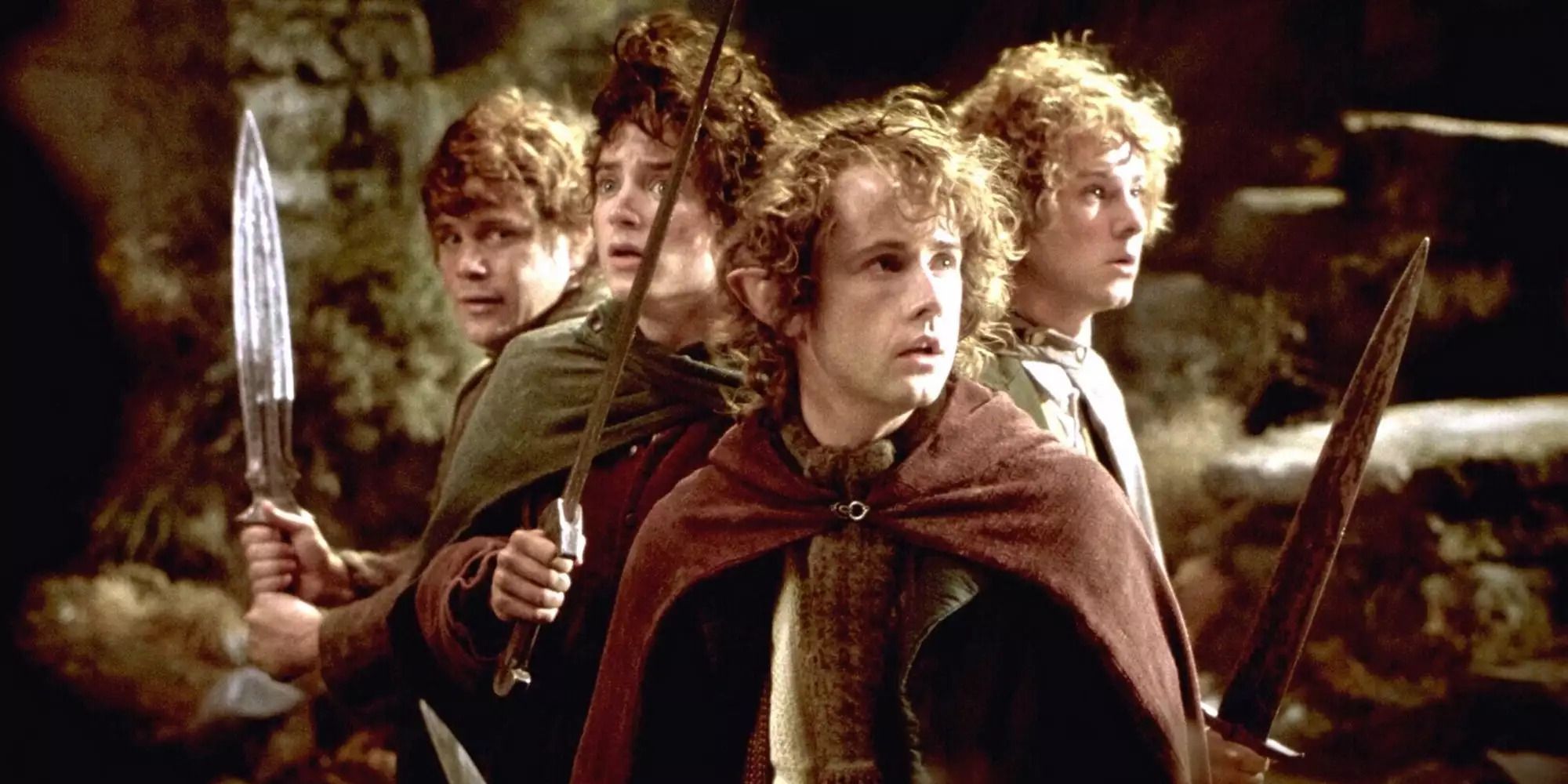 Hobbits Frodo, Sam, Merry and Pippin holding swords on Weathertop in 'The Lord of the Rings: The Fellowship of the Ring'