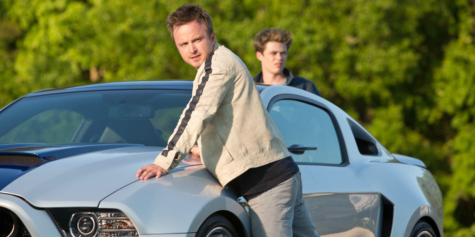 Tobey Marshall leans on the hood of his car