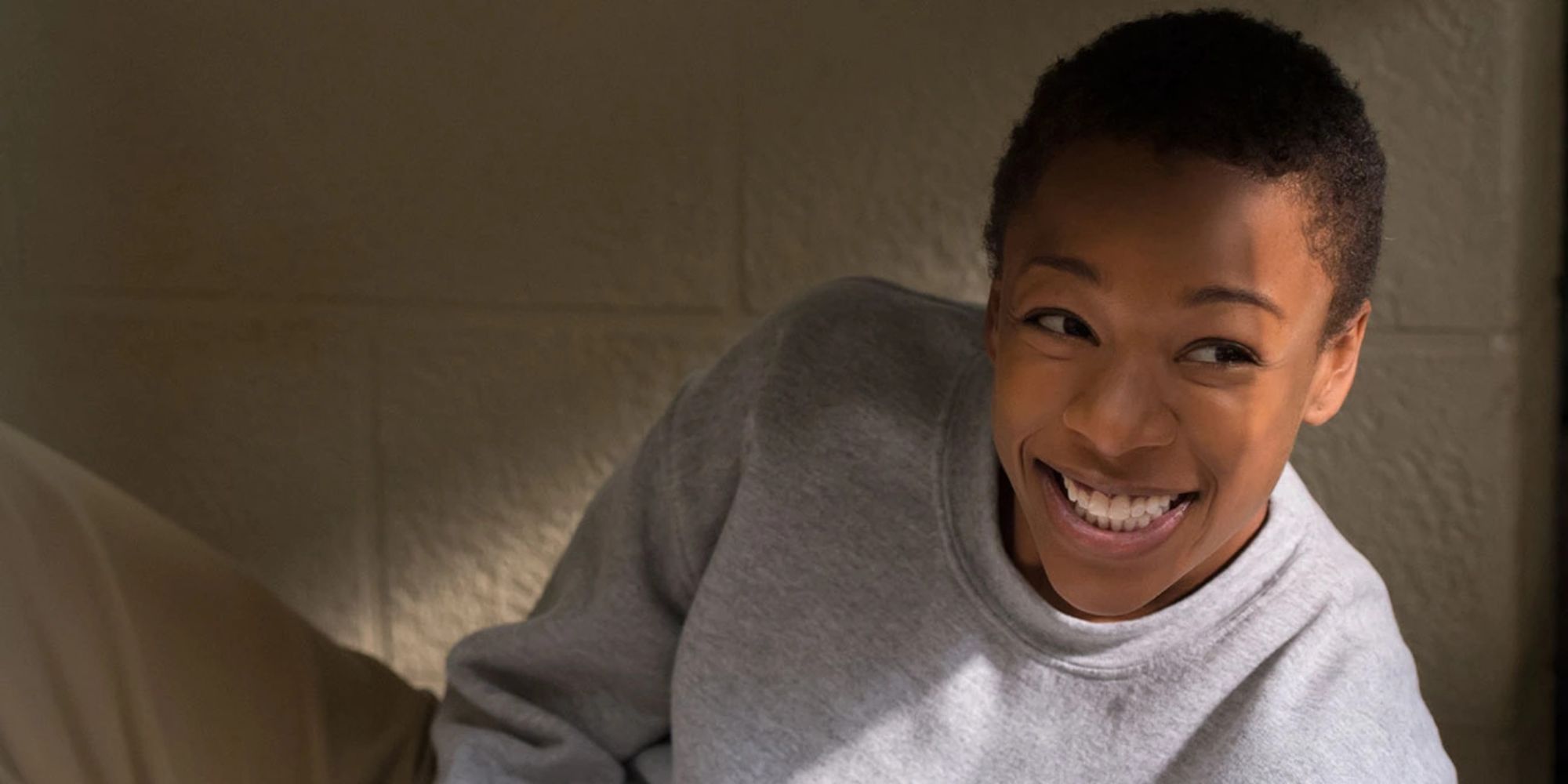 An inmate smiles as she lays in her cell