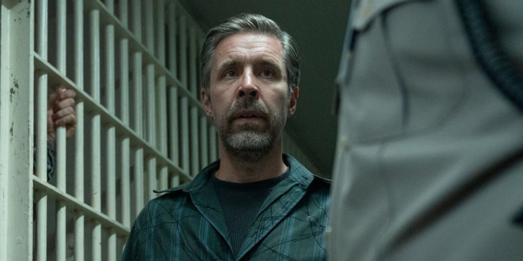 Paddy Considine walking into a jail cell in The Outsider