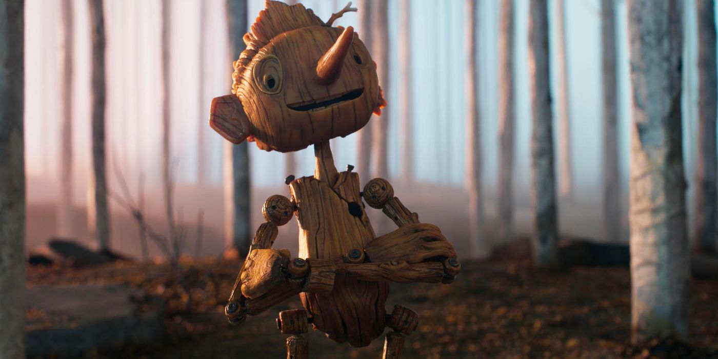 Pinocchio tersenyum dengan tangan bersilang di hutan di Pinocchio Guillermo del Toro di Netflix.