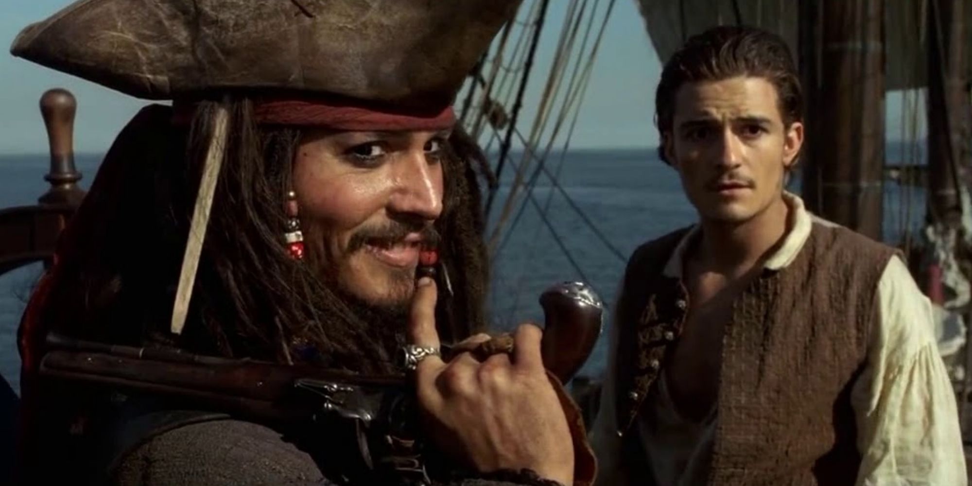 Jack Sparrow hält eine Waffe neben Will Turner aus „Pirates of the Caribbean: The Curse of the Black Pearl“