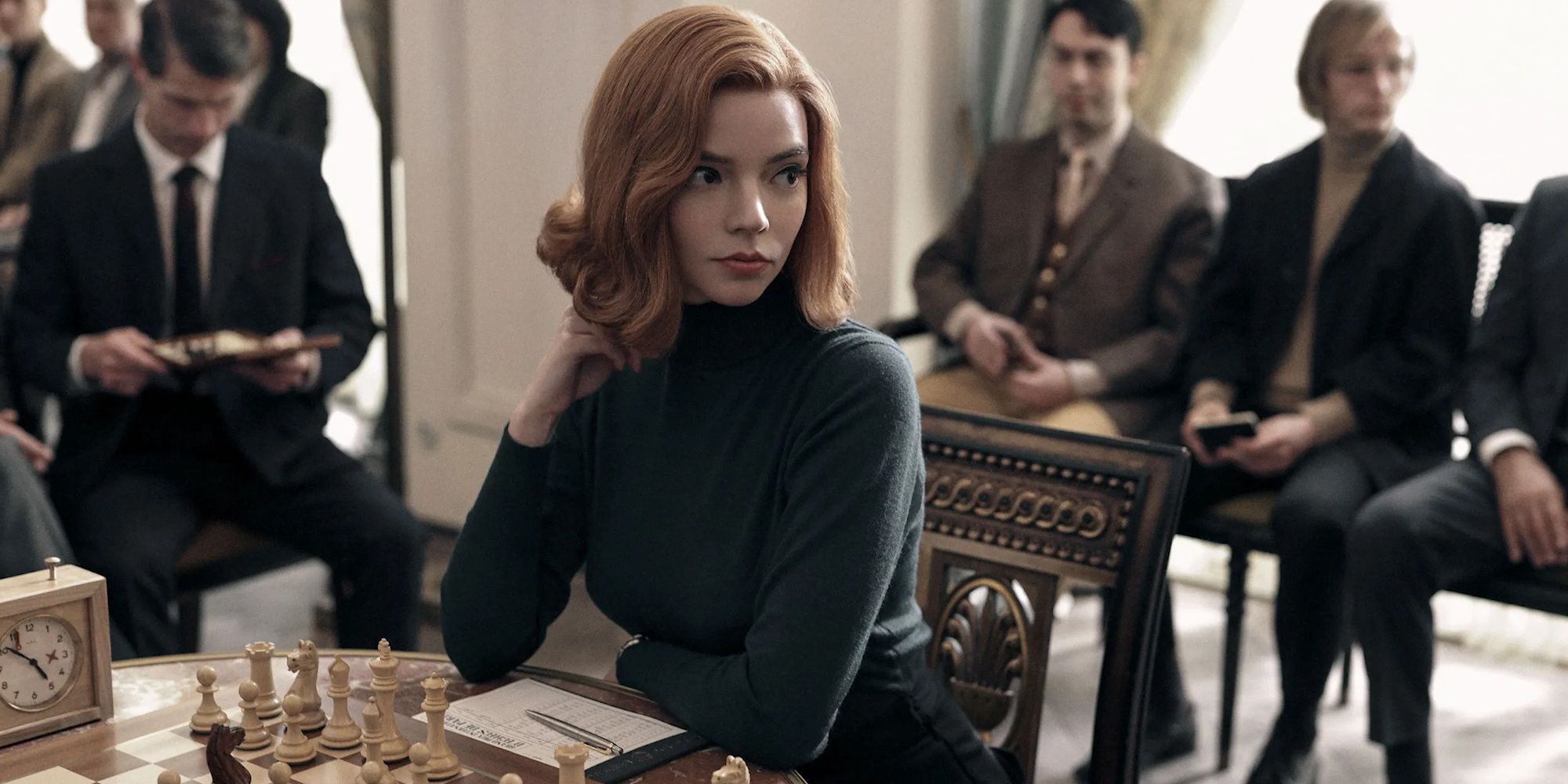 Anya Taylor-Joy as Beth Harmon, sitting in front of a chess board in The Queen's Gambit