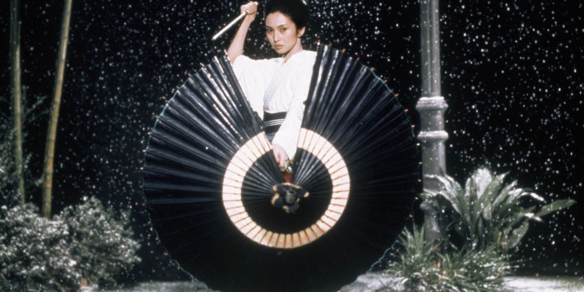 Lady Snowblood poses with a dagger and a parasol