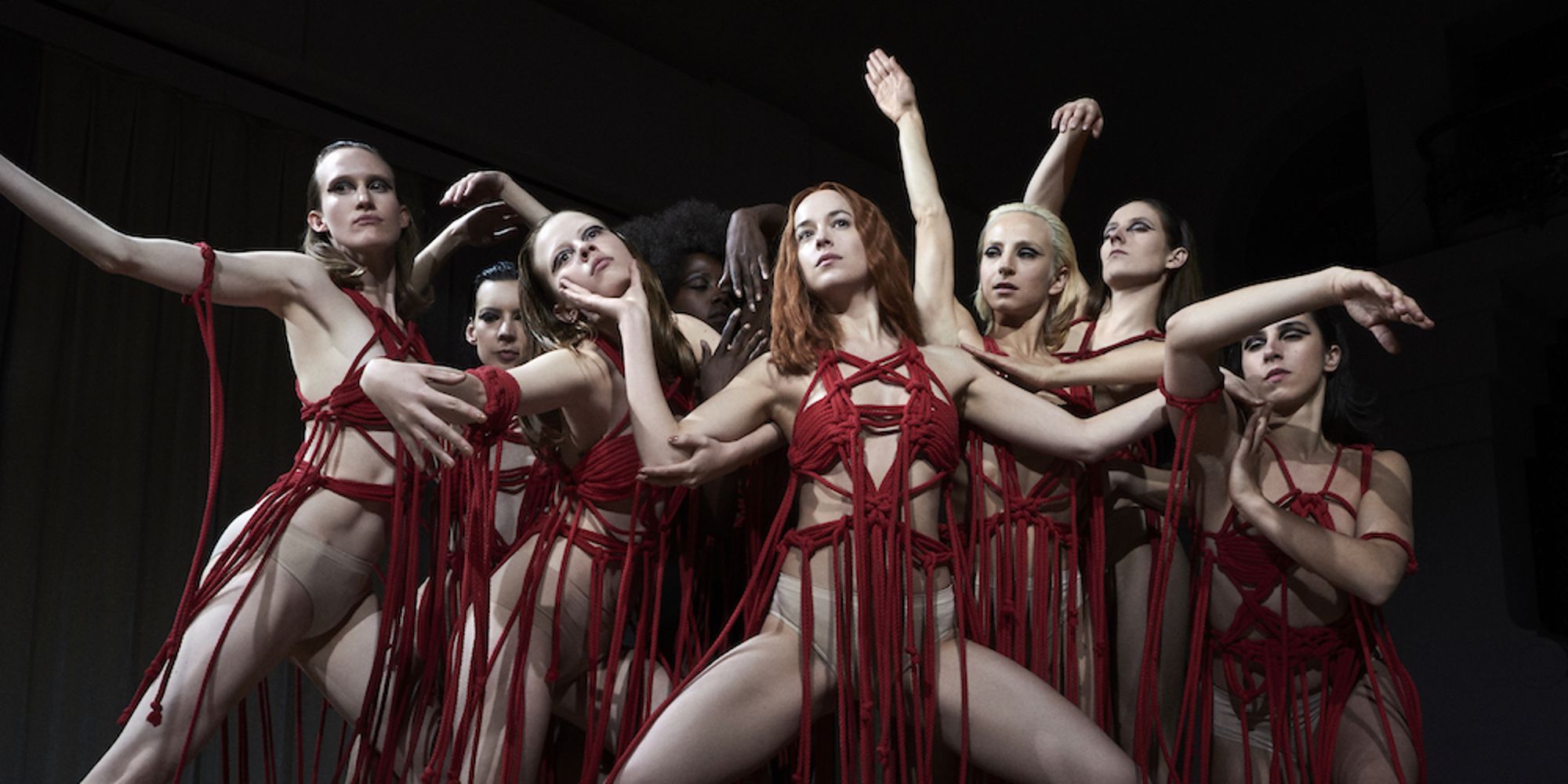 A ballet performance with Dakota Johnson and Mia Goth at the front in Suspiria