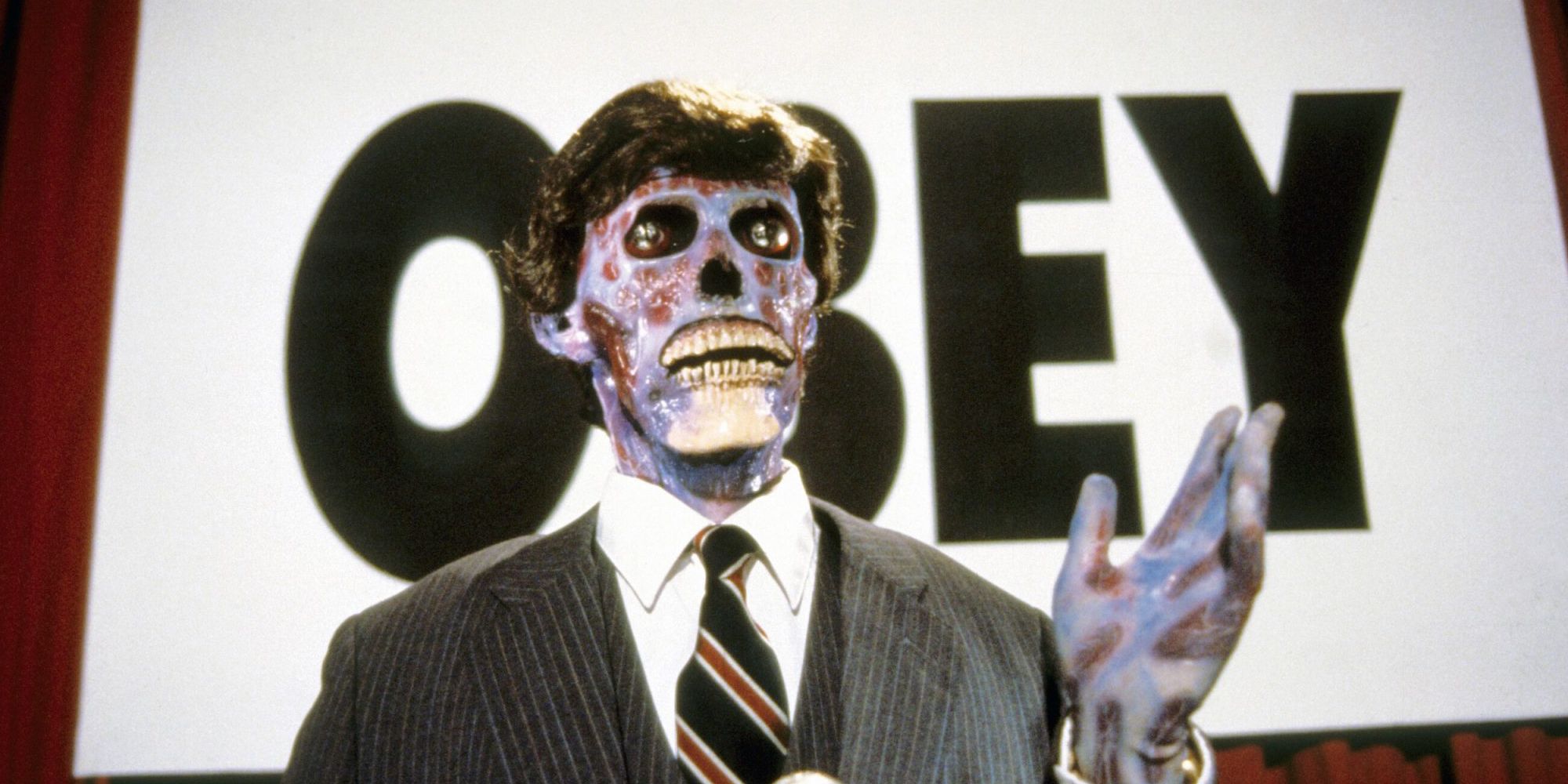 A zombie-like person giving a speech in front of a sign reading "obey" in They Live