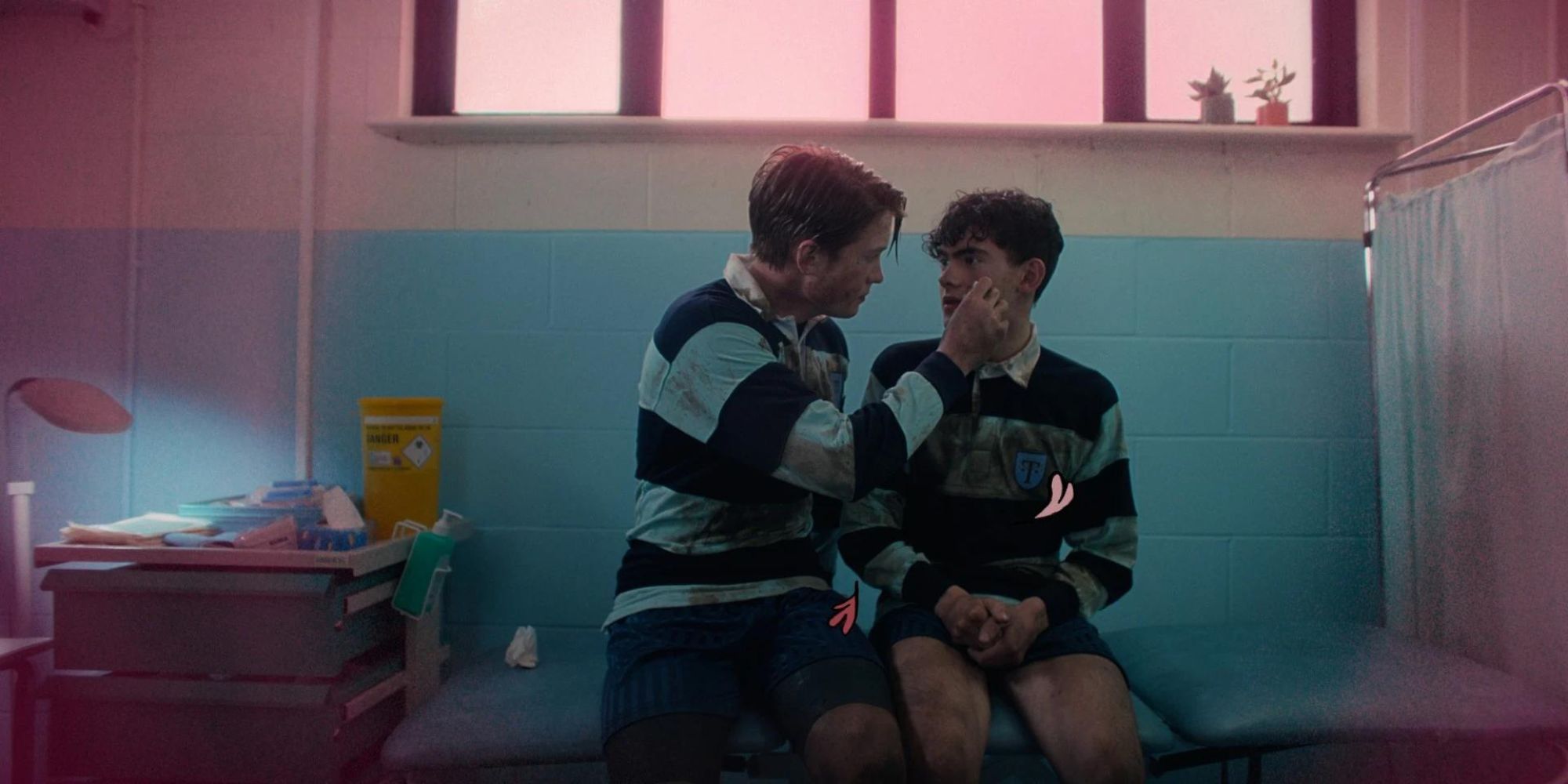Joe Locke and Kit Connor as Charlie Spring and Nick Nelson, sitting together as Nick tenderly touches Charlie&rsquo;s face after a tough rugby game on Heartstopper