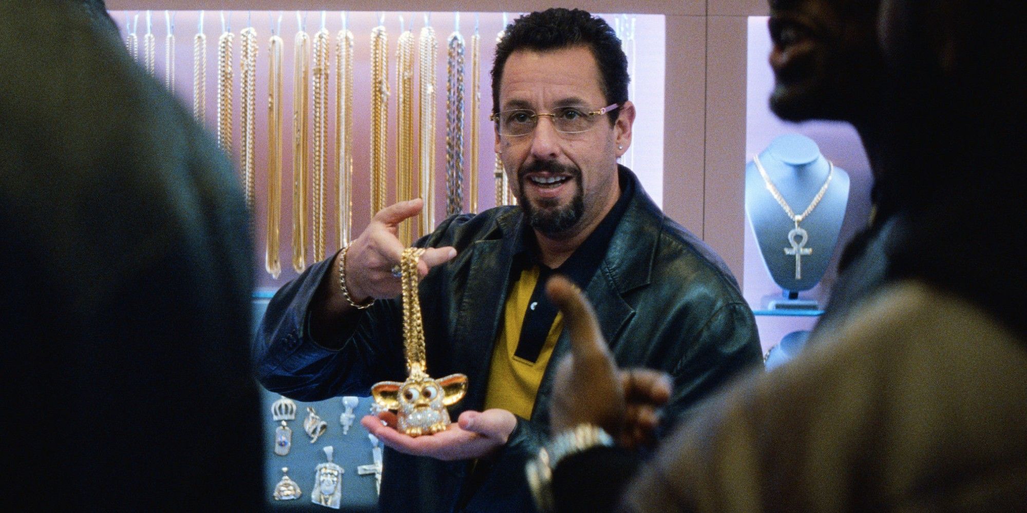 Adam Sandler holding a gold necklace in 'Uncut Gems'