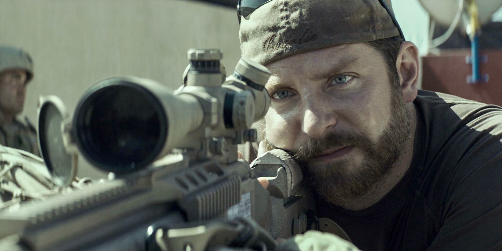 Bradley Cooper nei panni di Chris Kyle che punta un fucile da cecchino in American Sniper