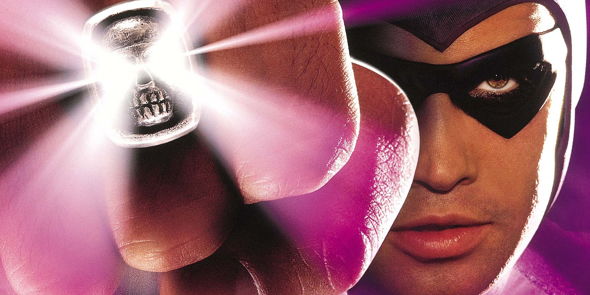 Billy Zane as The Phantom, in costume holding up a glowing skull ring