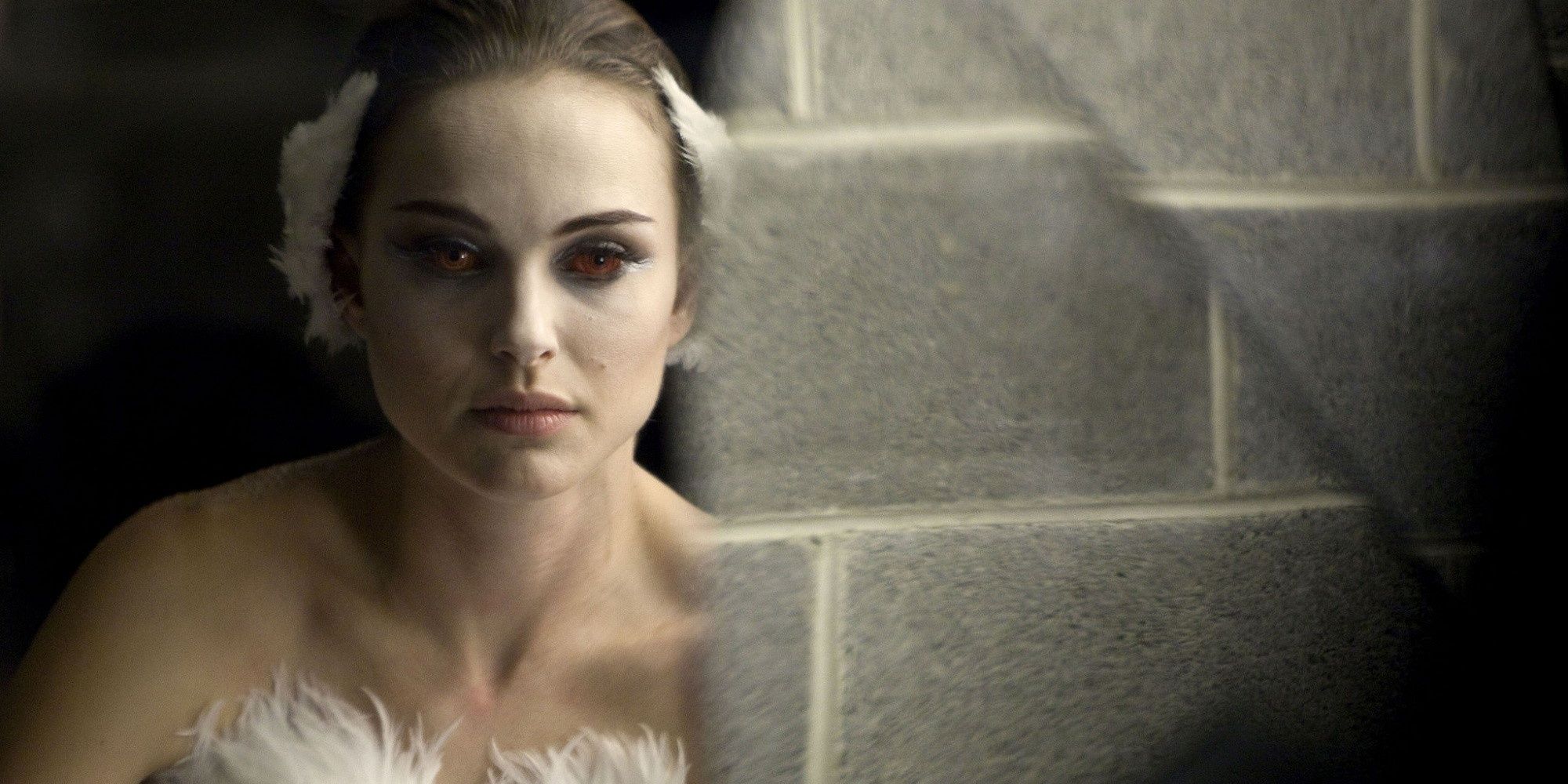 Natalie Portman's character, Nina, staring into a mirror at herself with blood red eyes.