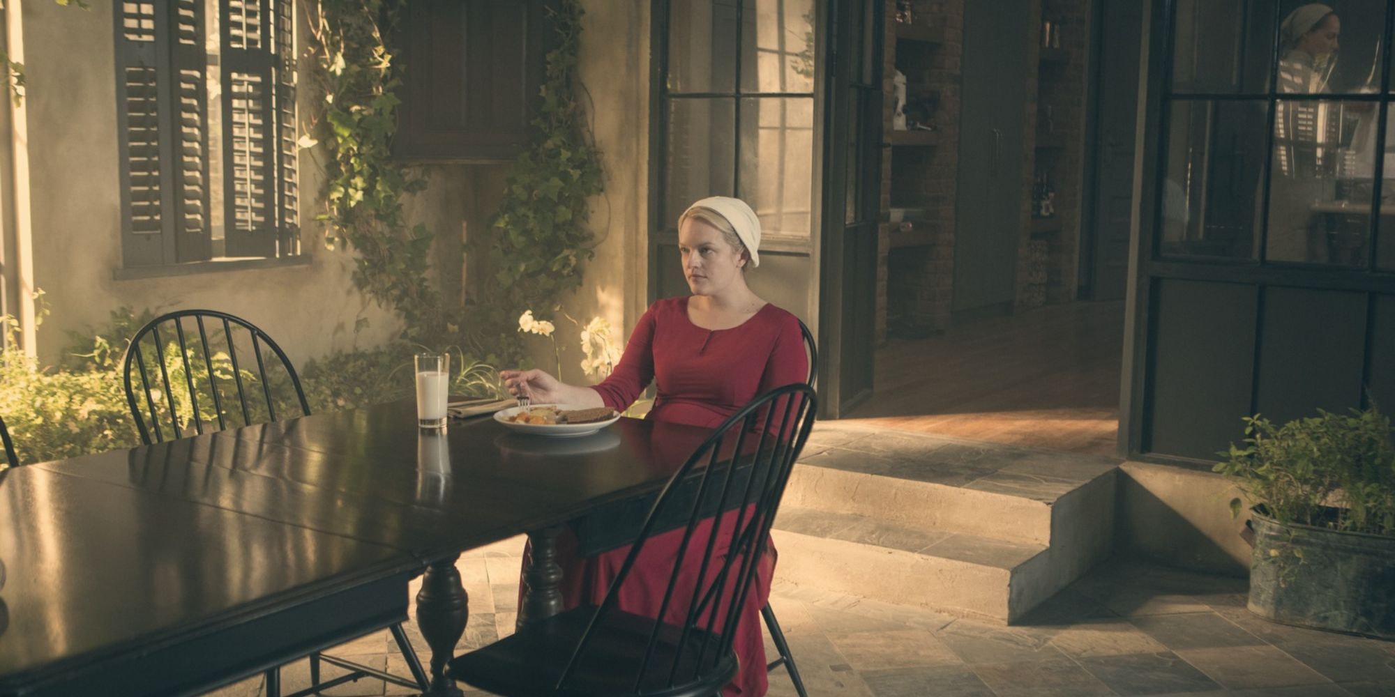 Offred sitting at the breakfast table