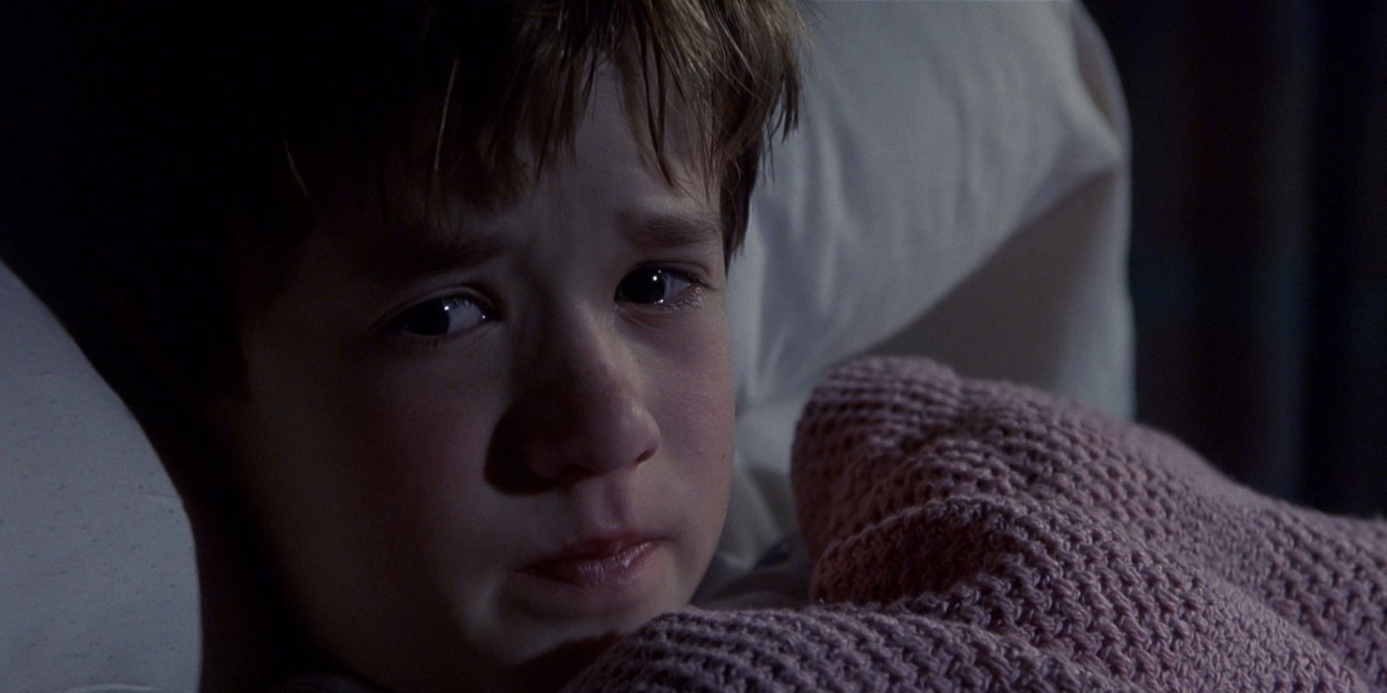 Cole Sear (Haley Joel Osment) lying in bed scared in the "I see dead people" scene of 'The Sixth Sense'