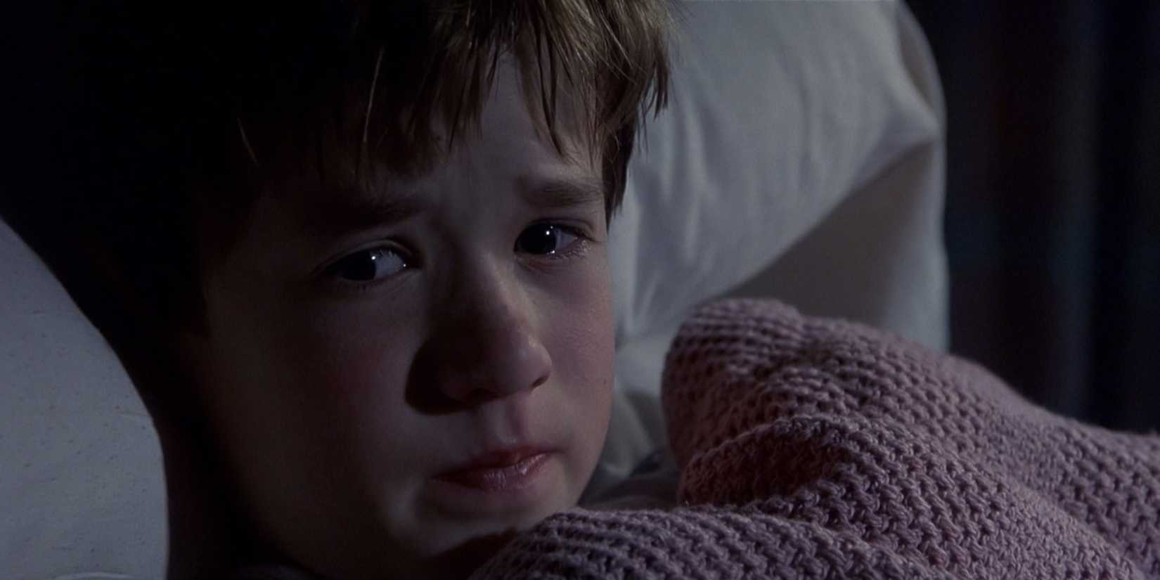 Cole Sear (Haley Joel Osment) is lying in bed, scared, in the "I see dead people" scene of The Sixth Sense.