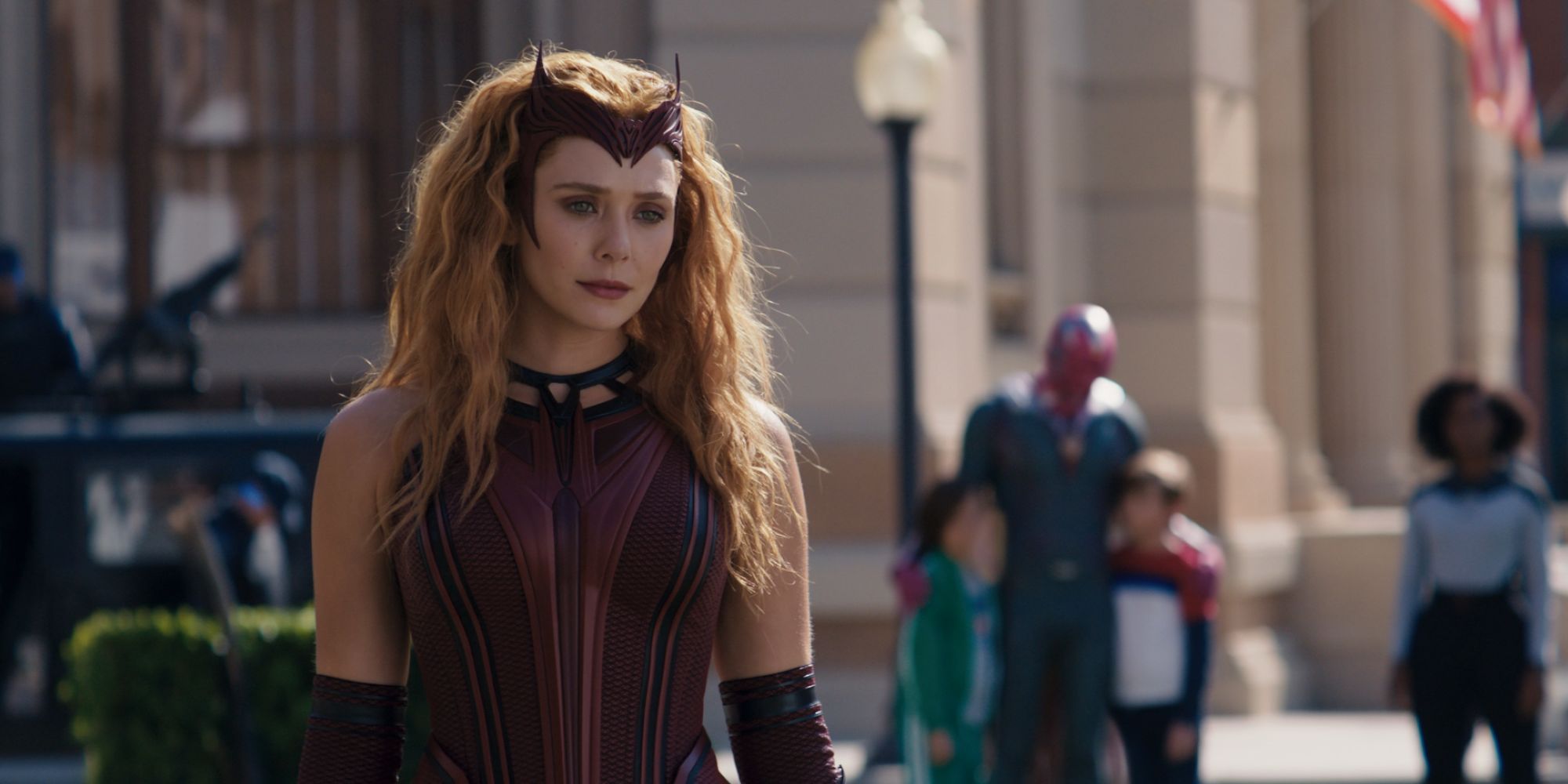 Wanda Maximoff, wearing her Scarlet Witch outfit on a city street in WandaVision