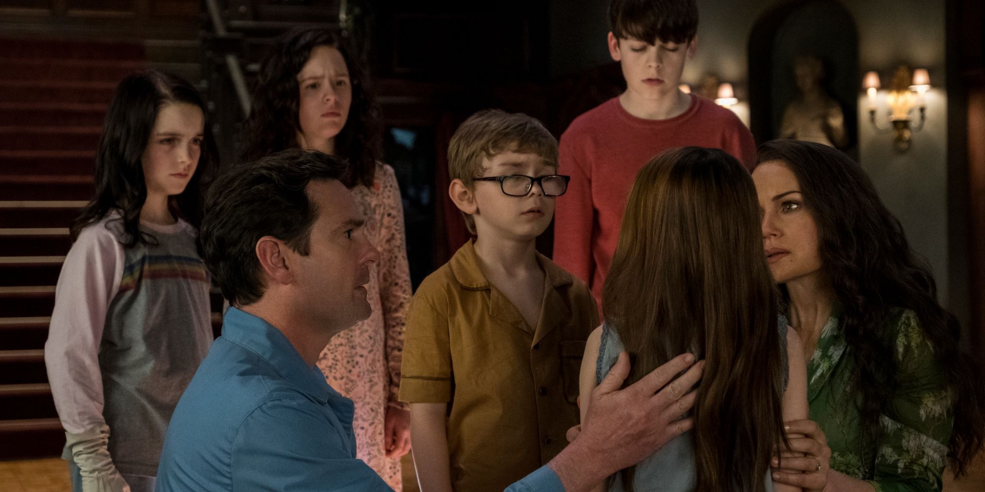 the crain family surrounding little nell in the haunting of hill house