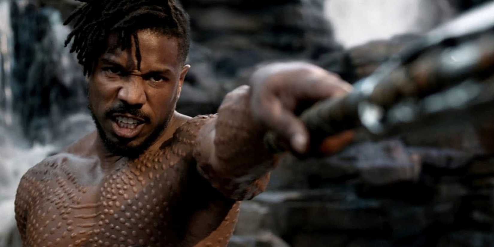 Michael B. Jordan as Erik Killmonger grimacing and pointing a weapon in 'Black Panther'.