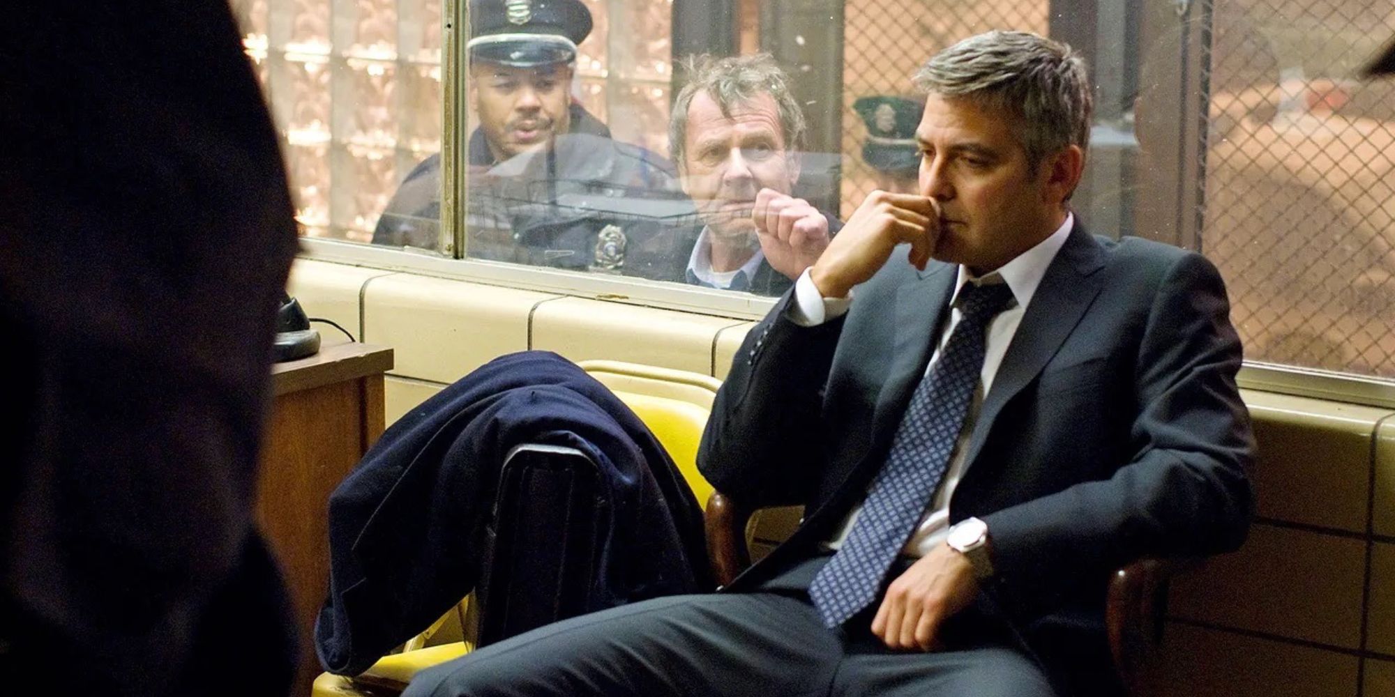 George Clooney stars as the titular Michael Clayton in this still from the film that features Clooney sitting in an office at a police station