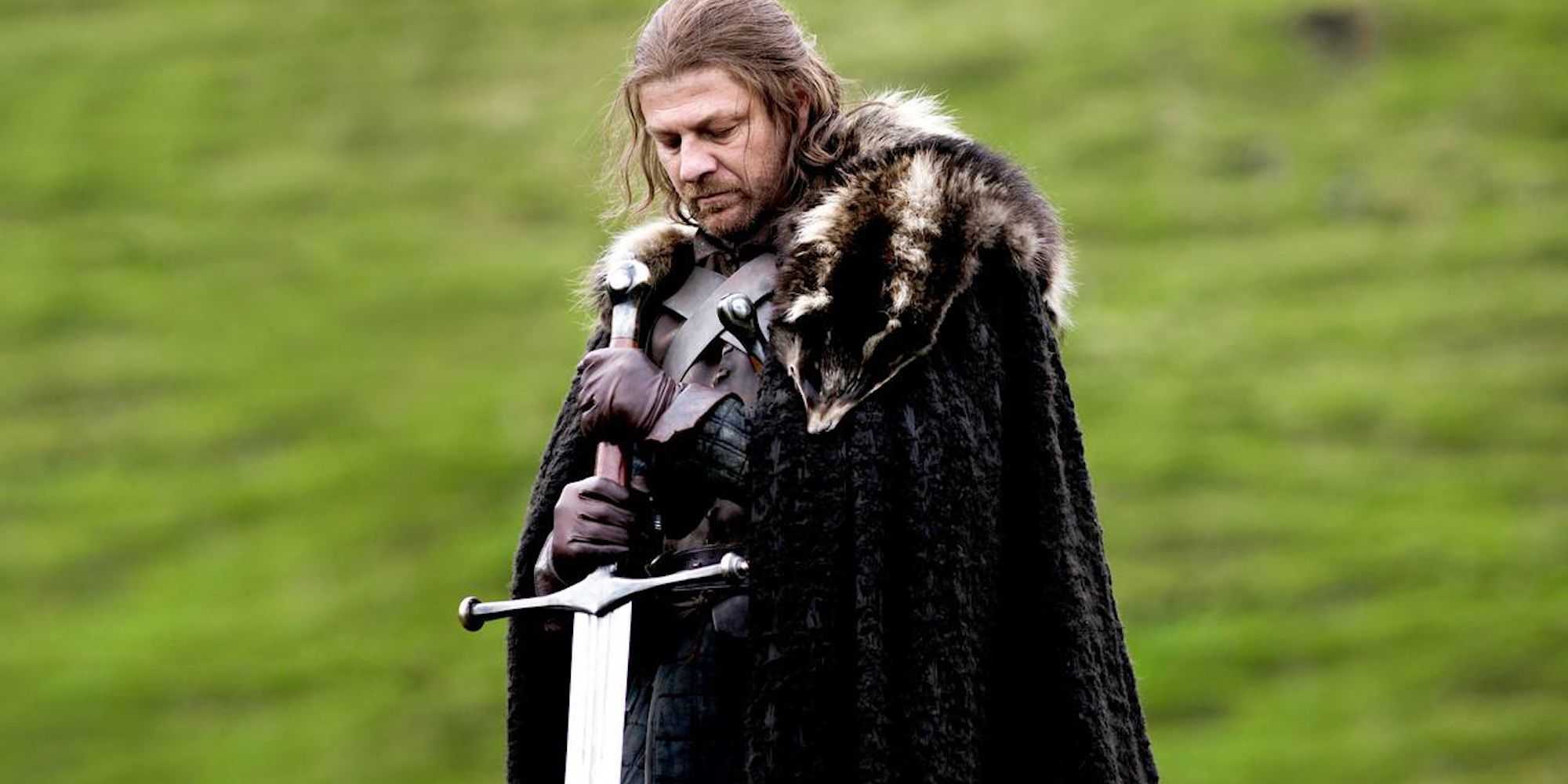 Ned Stark de Game of Thrones, vêtu d'une épaisse robe, tenant une grande épée dans le sol.