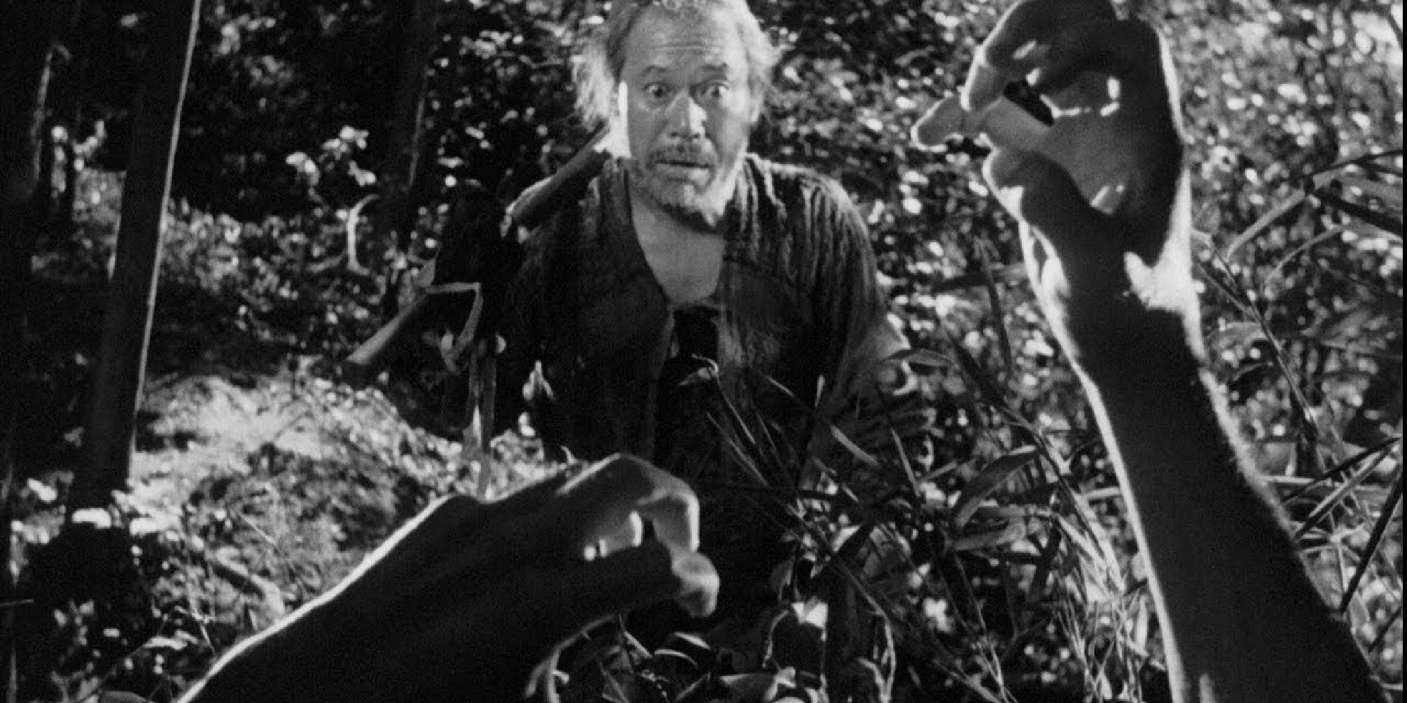 Toshiro Mifune as Tajomaru looking scared by pair of hands in Rashomon