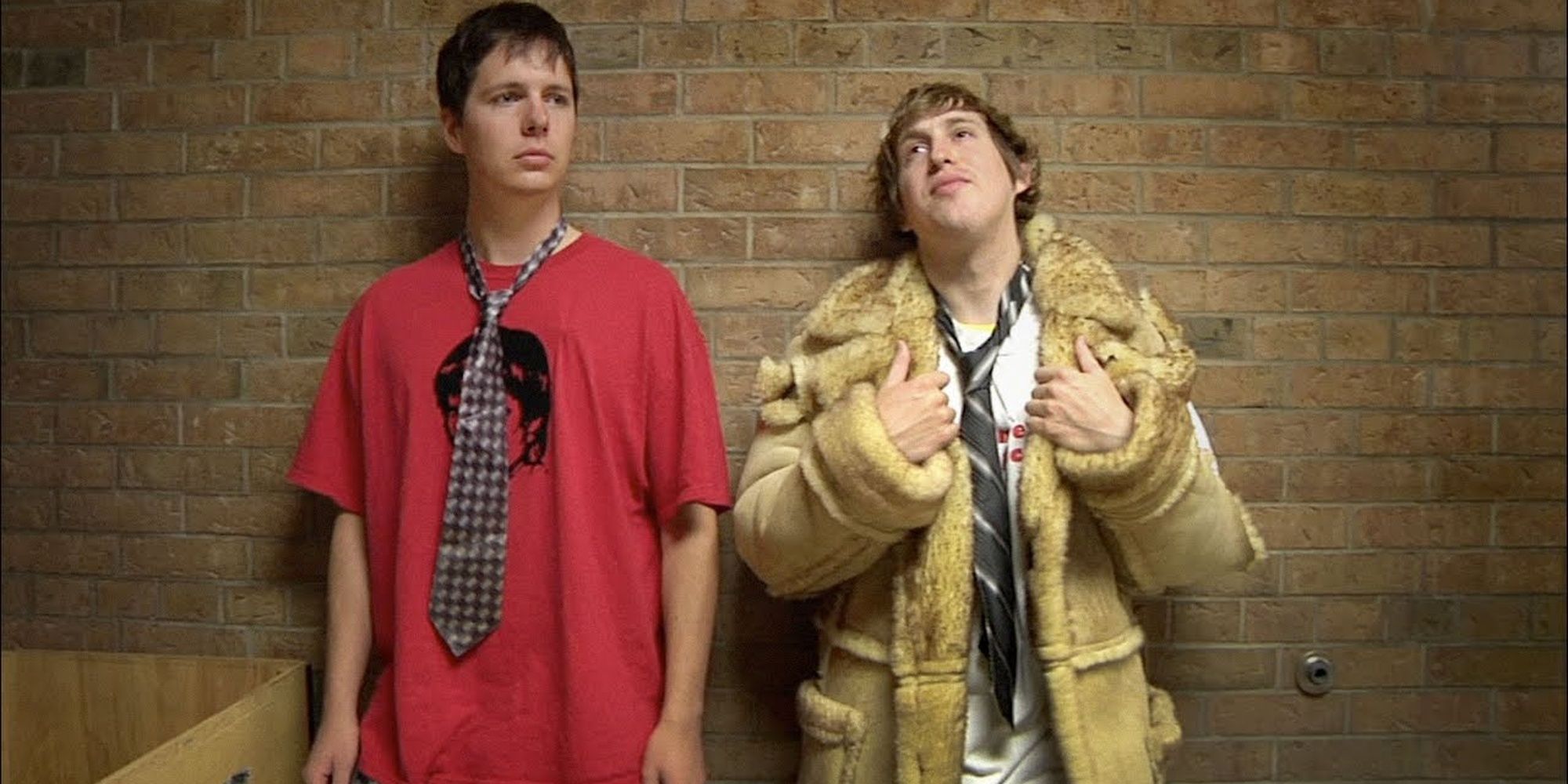 Two teens leaning against a wall