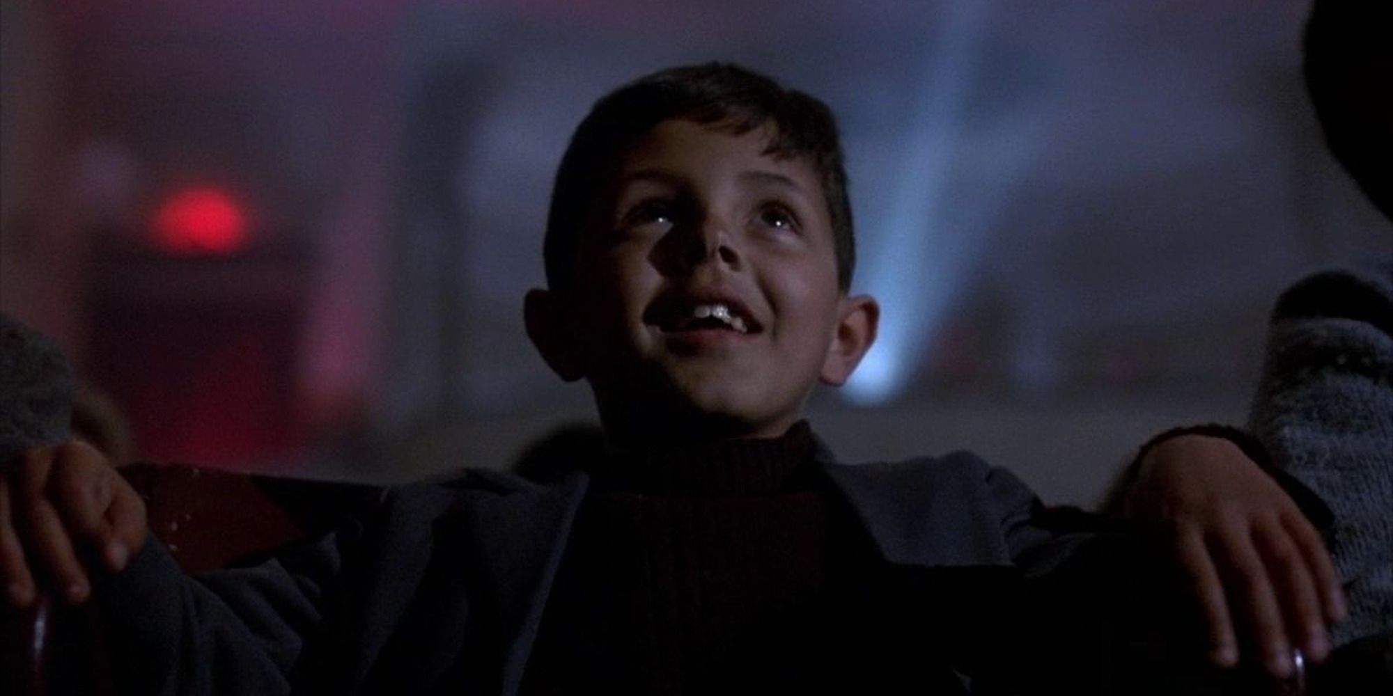 a young boy watching a movie in the theater