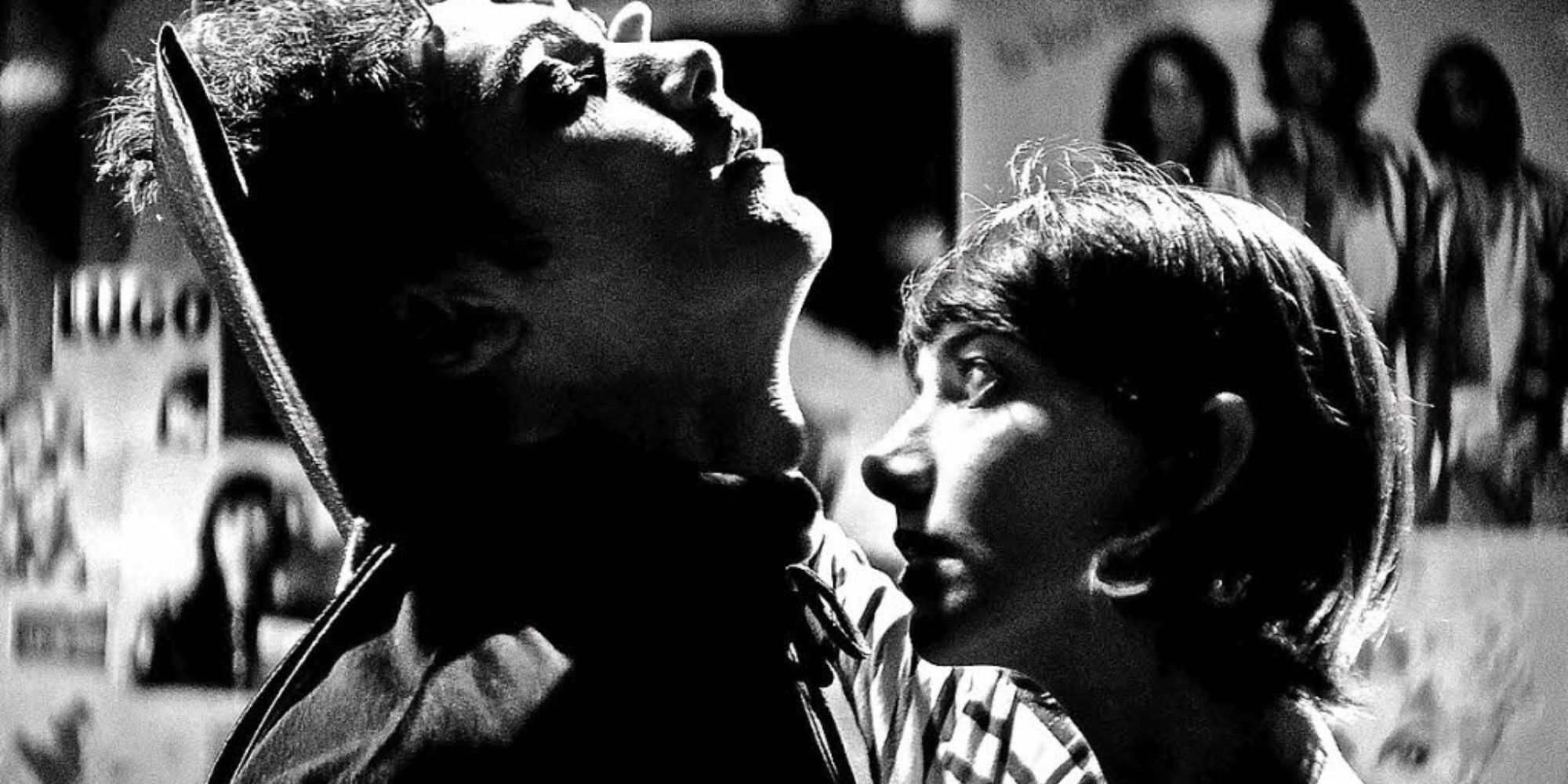 Imagem em preto e branco de uma adolescente cheirando o pescoço de um adolescente vestido de vampiro