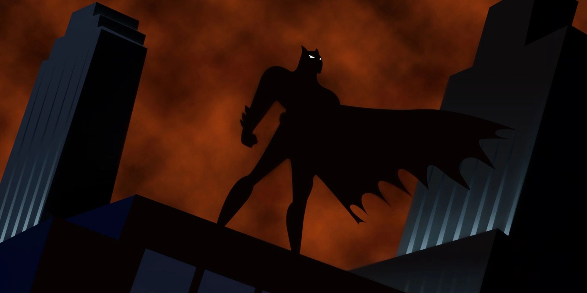 Batman on a rooftop in silhouette from the opening of 