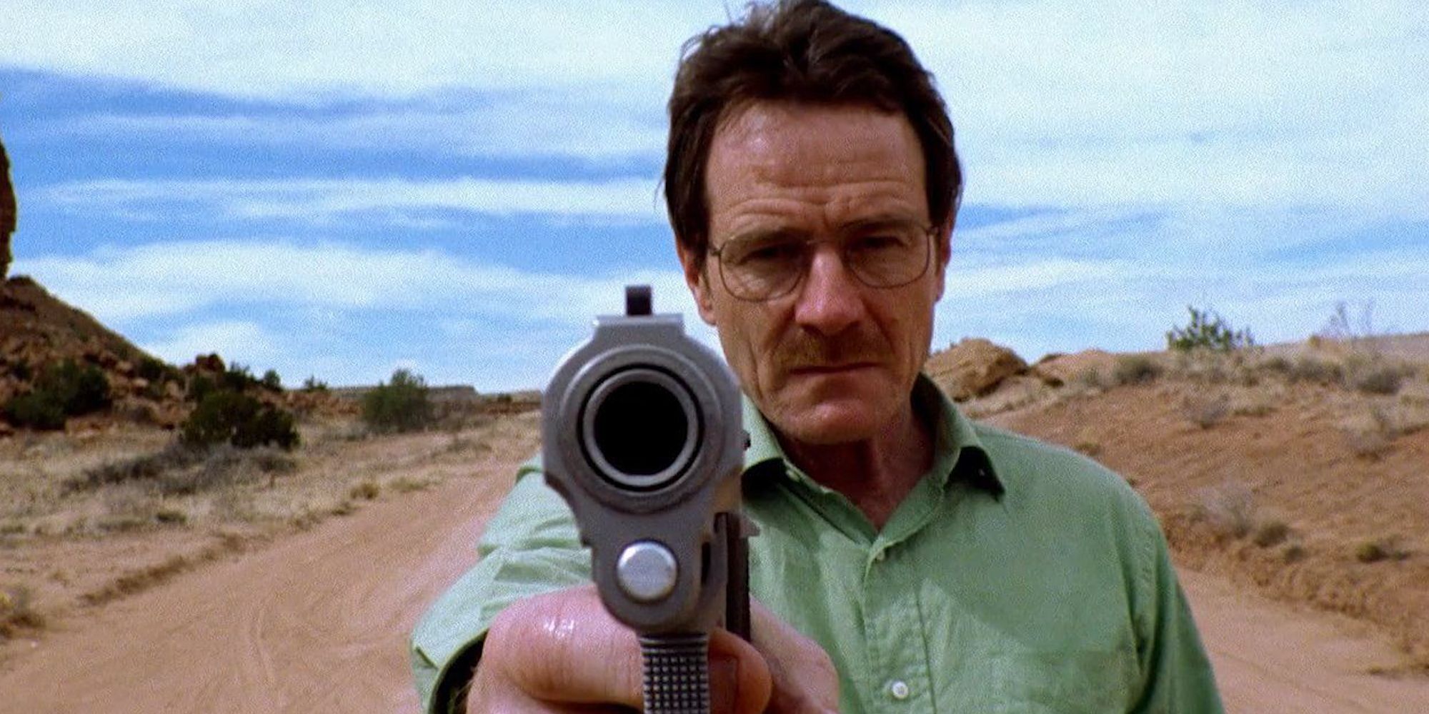 Bryan Cranston as Walter White pointing a gun at the camera in Breaking Bad