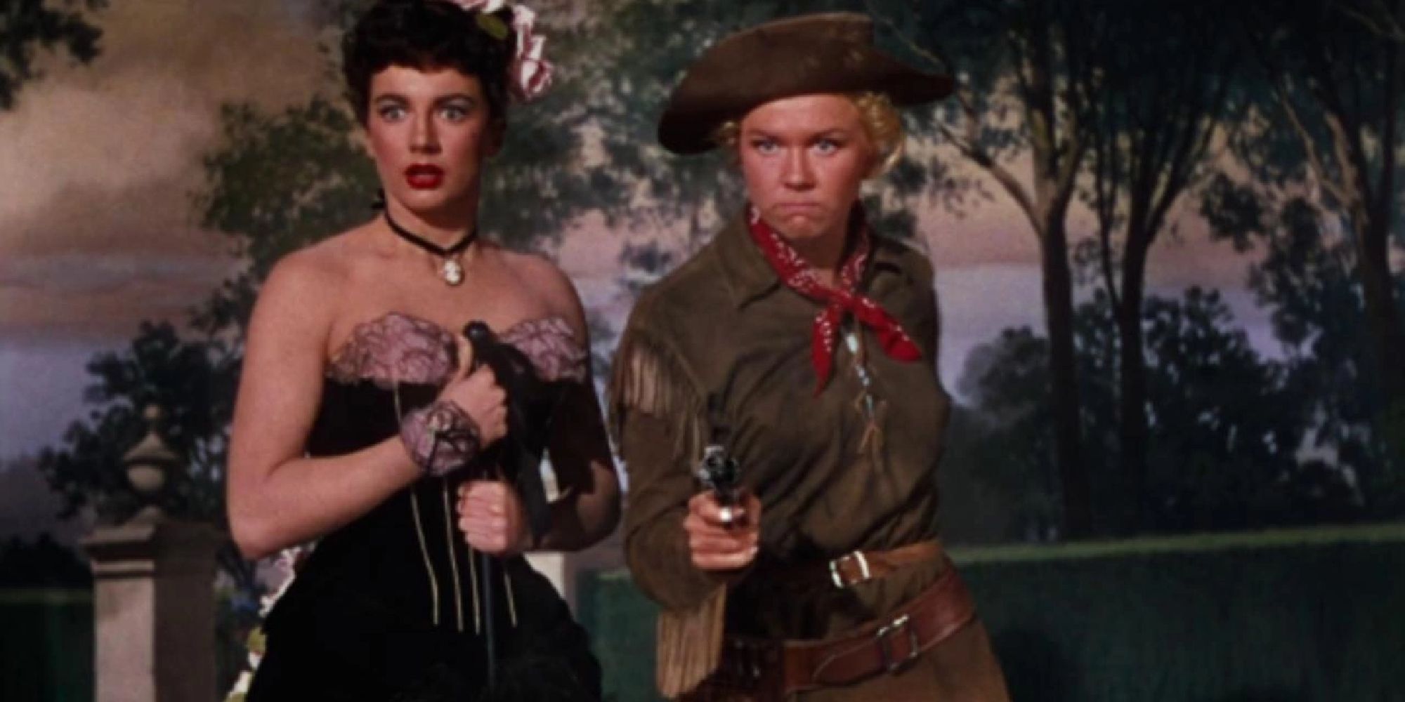 Doris Day wielding a gun with a showgirl by her side in Calamity Jane