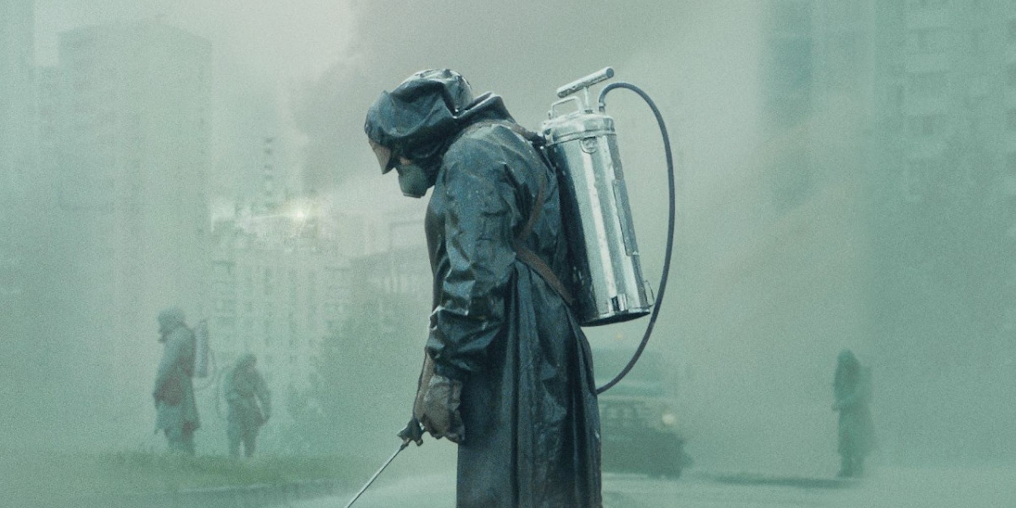 Una persona que lleva un traje protector en Chernobyl mira al suelo.