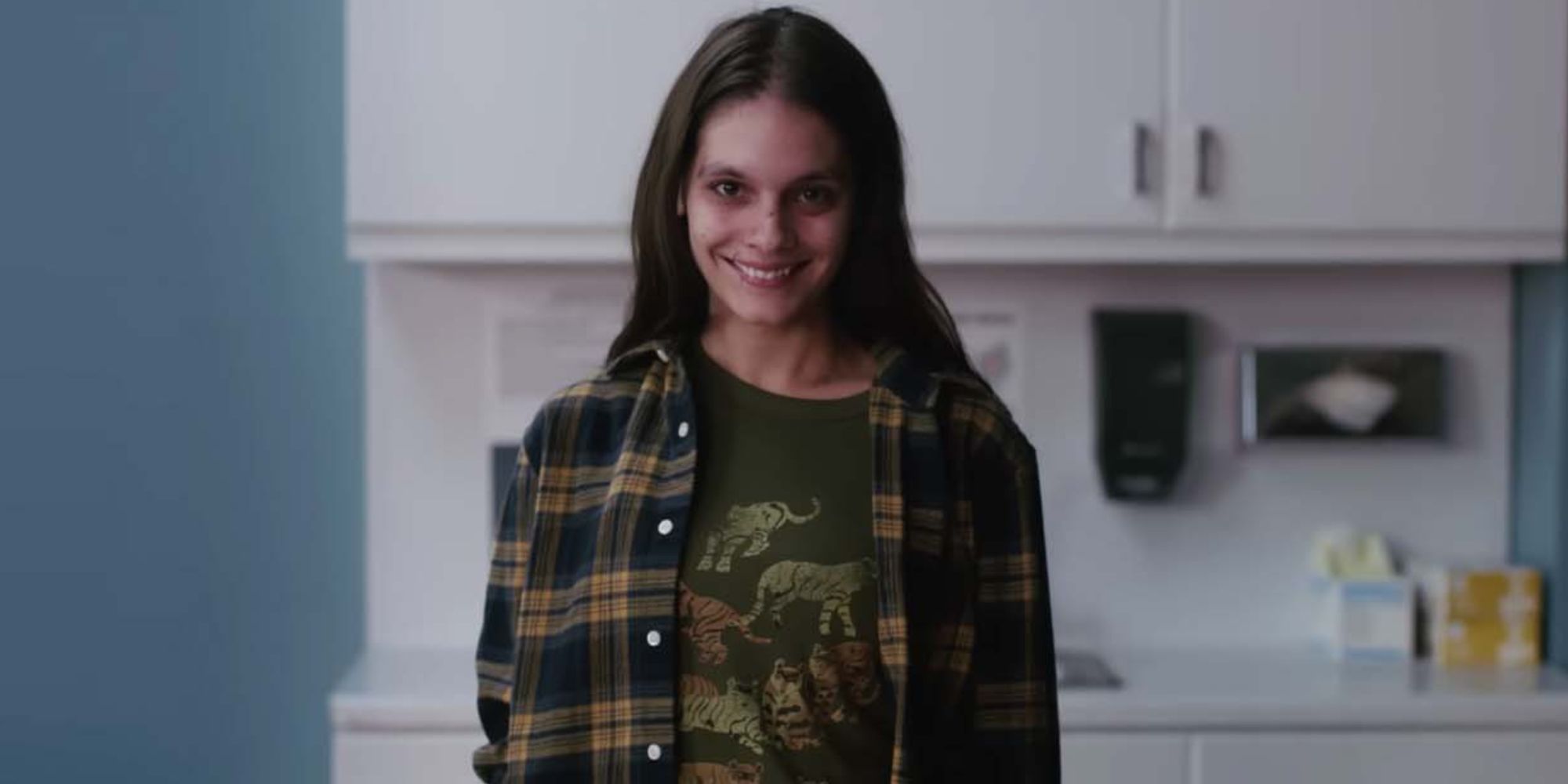Caitlin Stasey as Laura, a woman smiling creepily at the camera, from Smile (2022)