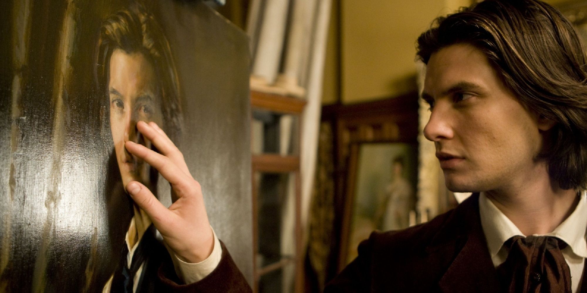 Dorian Gray touching his portrait in 'Dorian Gray.'