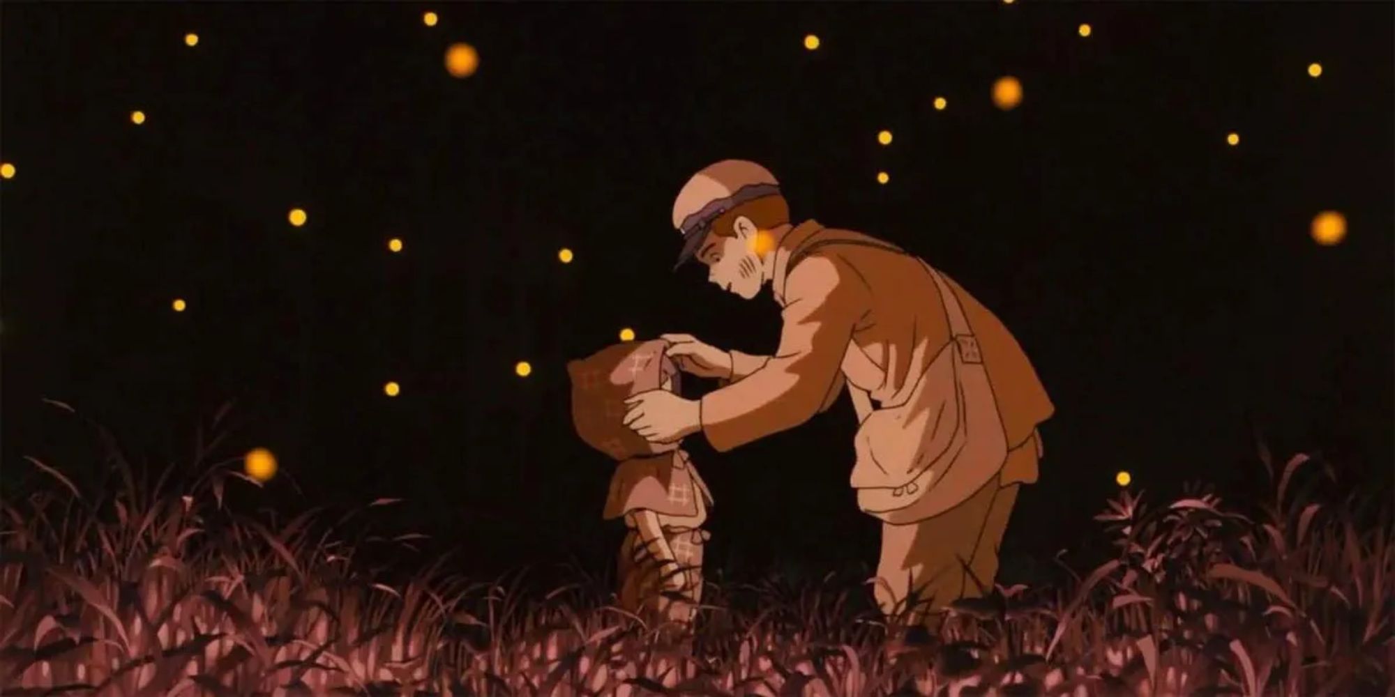 Seita dan Setsuko berdiri di lapangan berumput di malam hari sementara kunang-kunang beterbangan di sekitar mereka